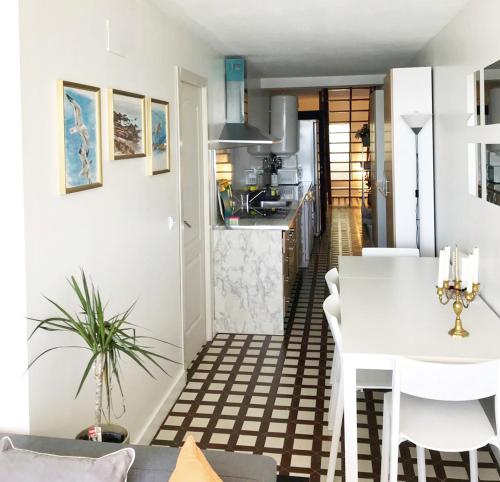 eine Küche und ein Wohnzimmer mit einem weißen Tisch und Stühlen in der Unterkunft Primera línea de mar apartamento dúplex en Ribeira in Ribeira