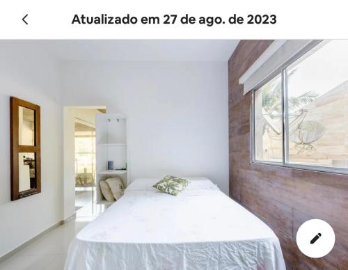 a bedroom with a white bed and a window at Vista Espetacular em Angra dos Reis in Angra dos Reis