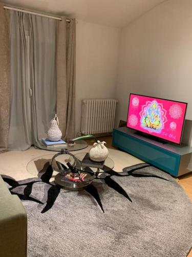 un salon avec une table et une télévision dans l'établissement Appartement agréable quartier des Grands Hommes, à Bordeaux