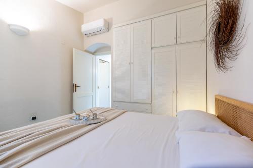 a bedroom with a white bed with a plate on it at Patio Relax - 200m from beach - Villasimius in Notteri