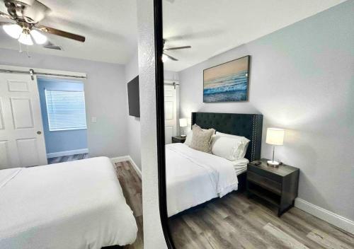 a bedroom with two beds and a ceiling fan at Downtown West Palm Apartment Near Airport in West Palm Beach