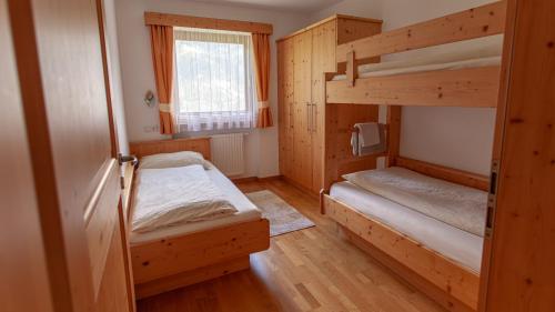 a room with two bunk beds and a window at Pretzerhof in Campo di Trens