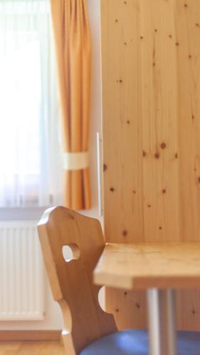 a wooden chair sitting next to a wooden wall at Pretzerhof in Campo di Trens