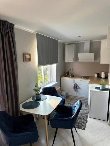 cocina con mesa y sillas azules en una habitación en Hugo 2, en Jēkabpils