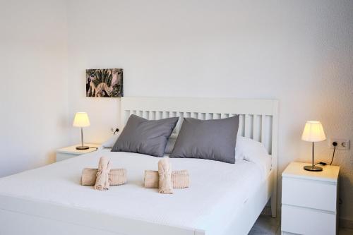 ein Schlafzimmer mit einem weißen Bett mit zwei Lampen in der Unterkunft Magnifico Apto. en Sueño Azul in Callao Salvaje
