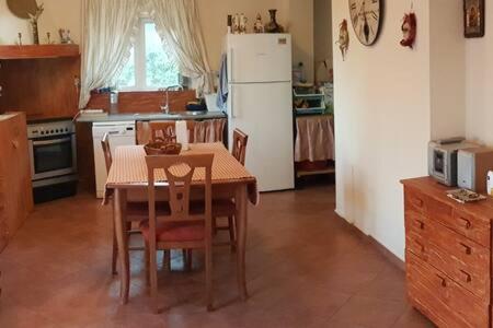 a kitchen with a table and a white refrigerator at Σπίτι με θέα in Nafpaktos