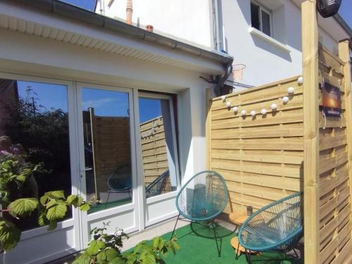a patio with two chairs and a fence at Gîte Lâchez Prise Sauna Balnéo Privatif en Baie d'Authie Verton Berck sur mer Meublé de tourisme classé 3 étoiles in Verton