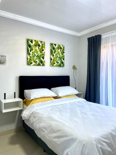 a bedroom with a large white bed with two windows at Ivywood loft @ Monarch Studios in Polokwane