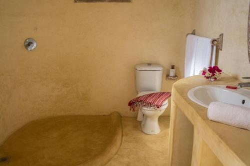 a bathroom with a tub and a toilet and a sink at Seaside Villa 1 & Seaside Villa 2 at 'Tamani' in Diani Beach