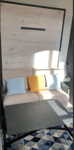 um sofá com almofadas num quarto em Vue Imprenable-Studio-Montauban em Montauban