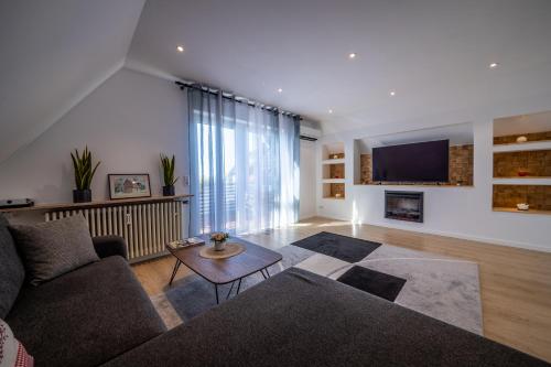 a living room with a couch and a tv at Renatas Ferienwohnung Sasbachwalden in Sasbachwalden