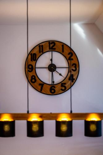 a clock hanging from a ceiling with lights at Renatas Ferienwohnung Sasbachwalden in Sasbachwalden