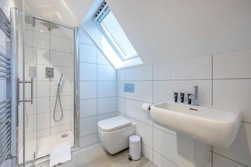ein Bad mit einem Waschbecken, einem WC und einem Fenster in der Unterkunft *RA7C* For your most relaxed & Cosy stay + Free Parking + Free Fast WiFi * in Batley