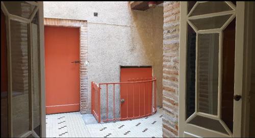 uma entrada para um edifício com uma porta vermelha em Vue Imprenable-Studio-Montauban em Montauban