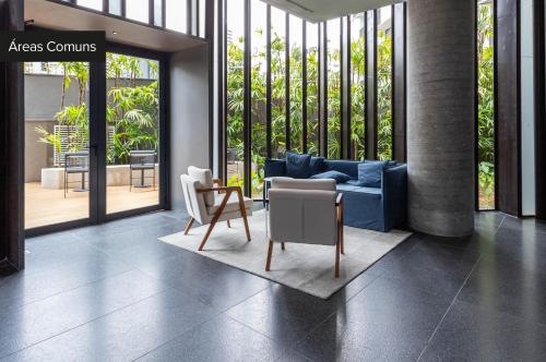 un salon avec un canapé bleu et une chaise dans l'établissement Charlie Onze22 Vila Madalena, à São Paulo