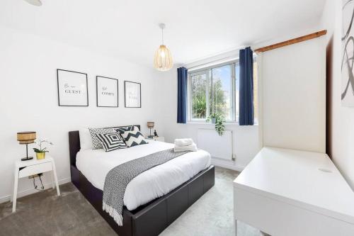 een slaapkamer met 2 bedden en een raam bij 3-bed apartment in Limehouse in Londen