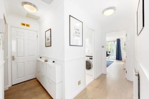 een witte hal met een wasmachine in een huis bij 3-bed apartment in Limehouse in Londen