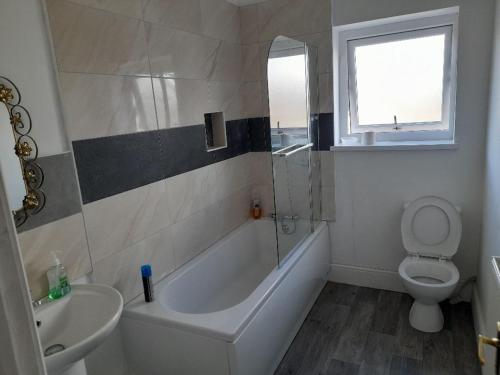 a bathroom with a tub and a toilet and a sink at ACCANE in Monkwearmouth