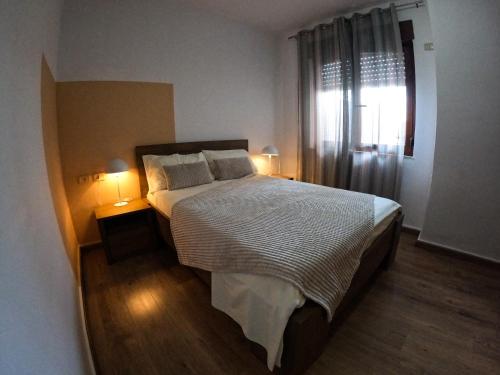 een slaapkamer met een bed met 2 lampen en een raam bij Getaway Tirana City Center - STAYcation Apartments in Tirana