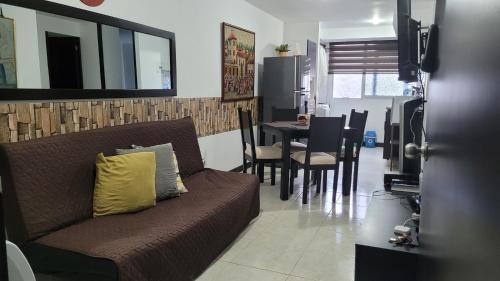 - un salon avec un canapé et une table avec des chaises dans l'établissement Tu Apartamento en el Eje Cafetero, à Montenegro