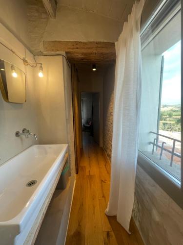 a bathroom with a white tub and a large window at Bnb Verdeolivo in Coriano