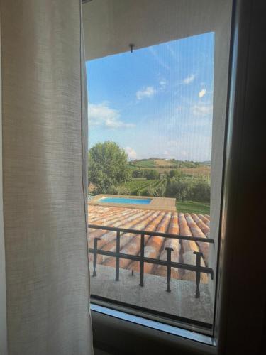 a window with a view of a pool from a house at Bnb Verdeolivo in Coriano