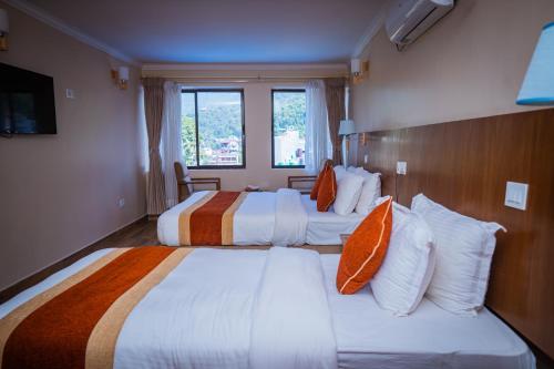 a hotel room with two beds and a window at Hotel Fewa Camp in Pokhara