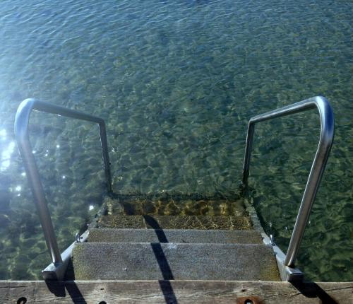 a set of stairs leading into the water at Strandhotel Strande in Strande