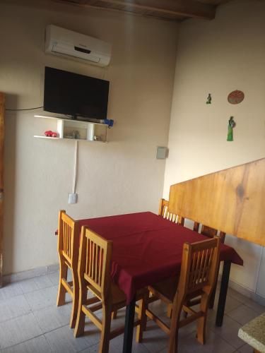 Un comedor con una mesa y sillas rojas. en F R F departamentos turisticos, en San Rafael