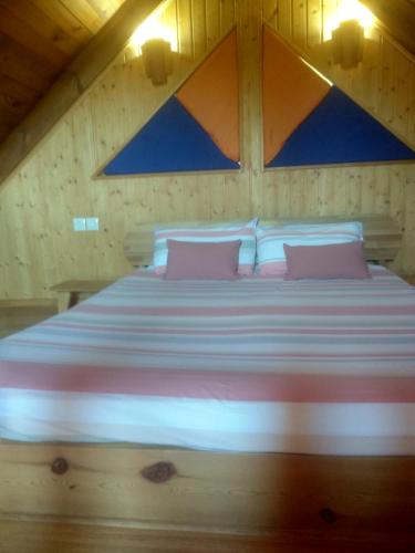 een groot bed met roze kussens in een kamer bij El Muerdago de Cañada in Cañada del Hoyo