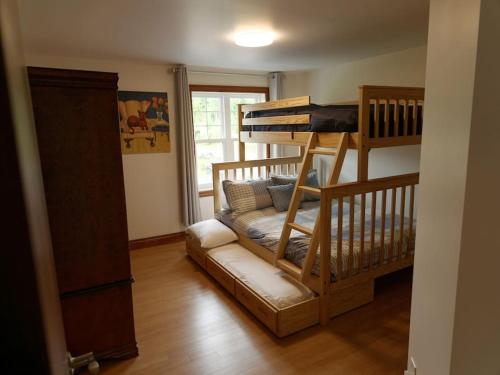 a room with two bunk beds and a couch in it at Equipped condo on St-Pierre Lake, Kamouraska RCM in Mont-Carmel