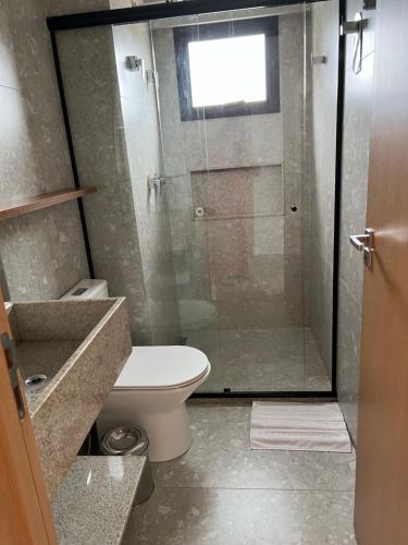 a bathroom with a toilet and a glass shower at Salinas Premium Resort Ap 1 QT in Salinópolis