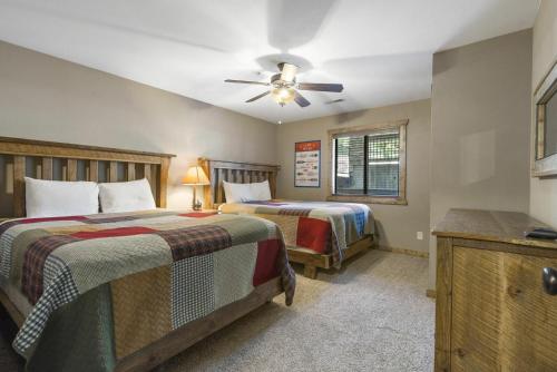 a bedroom with two beds and a ceiling fan at Table Rock Resorts at Indian Point in Branson