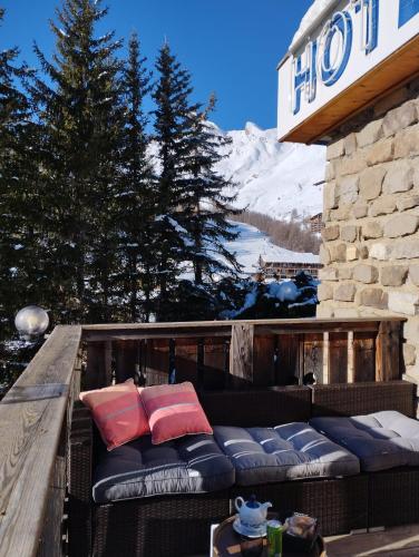 a balcony with a couch on the side of a building at Hotel Restaurant La Source in La Foux
