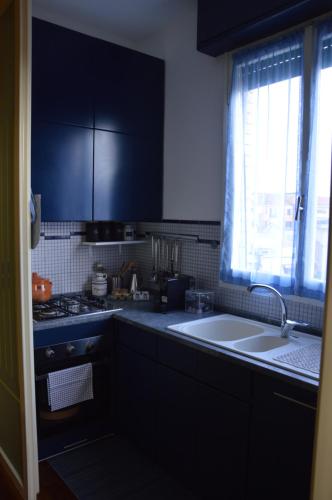 cocina con armarios negros, fregadero y ventana en Casa Benny, en Milán