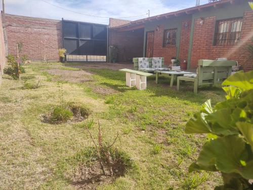 un patio con dos bancos y un edificio en F R F departamentos turisticos en San Rafael