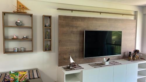 a living room with a flat screen tv on a wall at Flat Confort Pé na Areia in Ipojuca