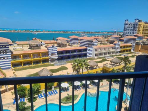 a view of a resort with a pool and a beach at PORTO MARINA TOWERS SEA & POOL VIEW North Coast in El Alamein