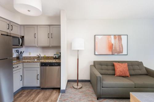 a living room with a couch and a kitchen at Candlewood Suites Eagan - Mall of America Area by IHG in Eagan