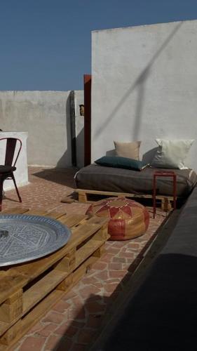 a bedroom with a bed and a table and a chair at Tarbi'aat Tetaoun 44, 17th century heritage in Tetouan