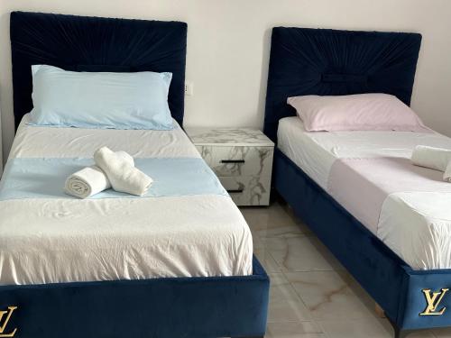 two beds in a room with towels on them at Shell Home golem 1 in Golem