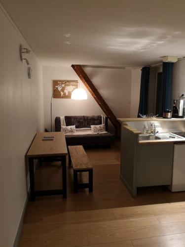 a kitchen and living room with a table and a couch at Hypercentre résidence paisible in Fontainebleau