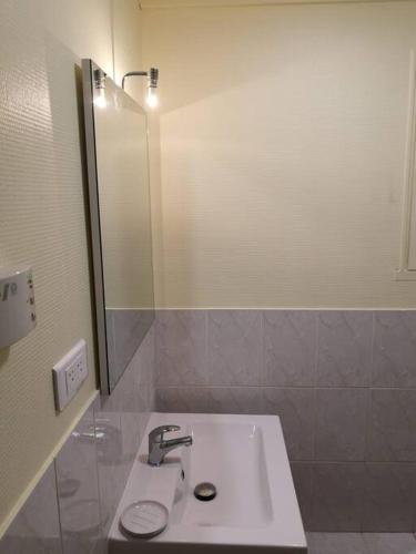 une salle de bain avec un lavabo et un miroir dans l'établissement Hypercentre résidence paisible, à Fontainebleau