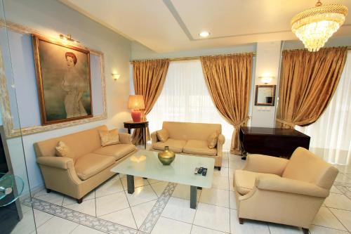 a living room with two couches and a table at Triton Hotel Piraeus in Piraeus