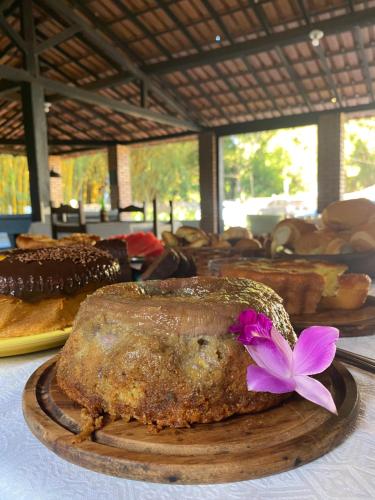 a loaf of bread with a purple flower on a table at Pousada Cantinho do Mundo in Brumadinho