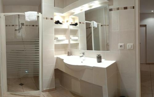 ein weißes Bad mit einem Waschbecken und einer Dusche in der Unterkunft Le Four à Pain, Gîte avec piscine et SPA proche Sarlat in Marquay