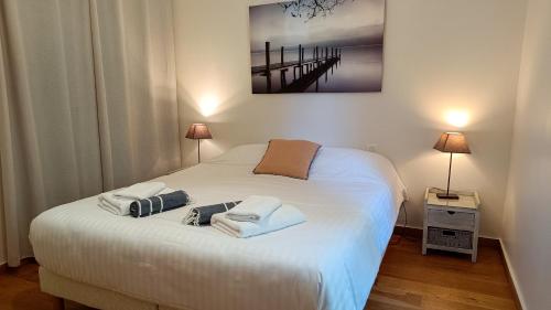 ein Schlafzimmer mit einem Bett mit zwei Handtüchern darauf in der Unterkunft Le Four à Pain, Gîte avec piscine et SPA proche Sarlat in Marquay