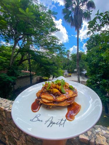 a white plate with a dish of food on it at The Mayan Garden in Orange Walk