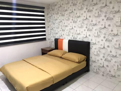 Un dormitorio con una cama y una pared con dibujos. en Pangkor Island CoralBay Private Apartment en Pasir Bogak