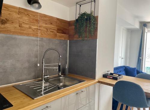 a kitchen with a stainless steel sink and wooden counters at Le Nautica - Proche CDG - 4 Prs - Balcon in Sevran